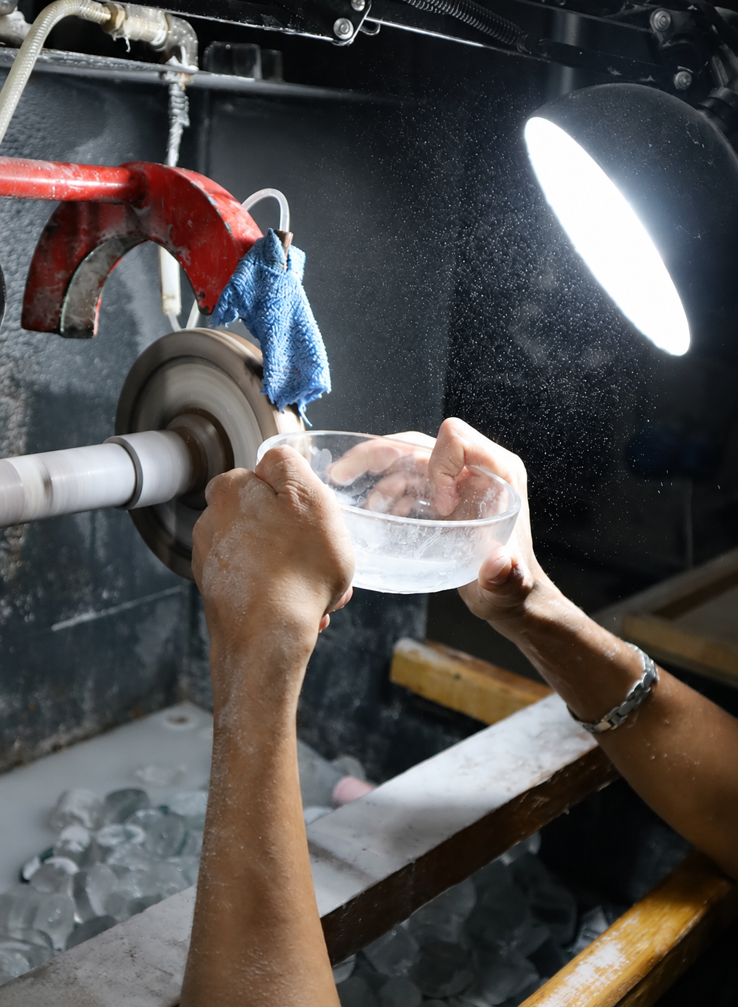 Craftsperson working a glass bowl at a polishing wheel